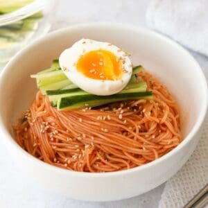 Transfer noodles to serving bowl and top off with sliced cucumbers and egg