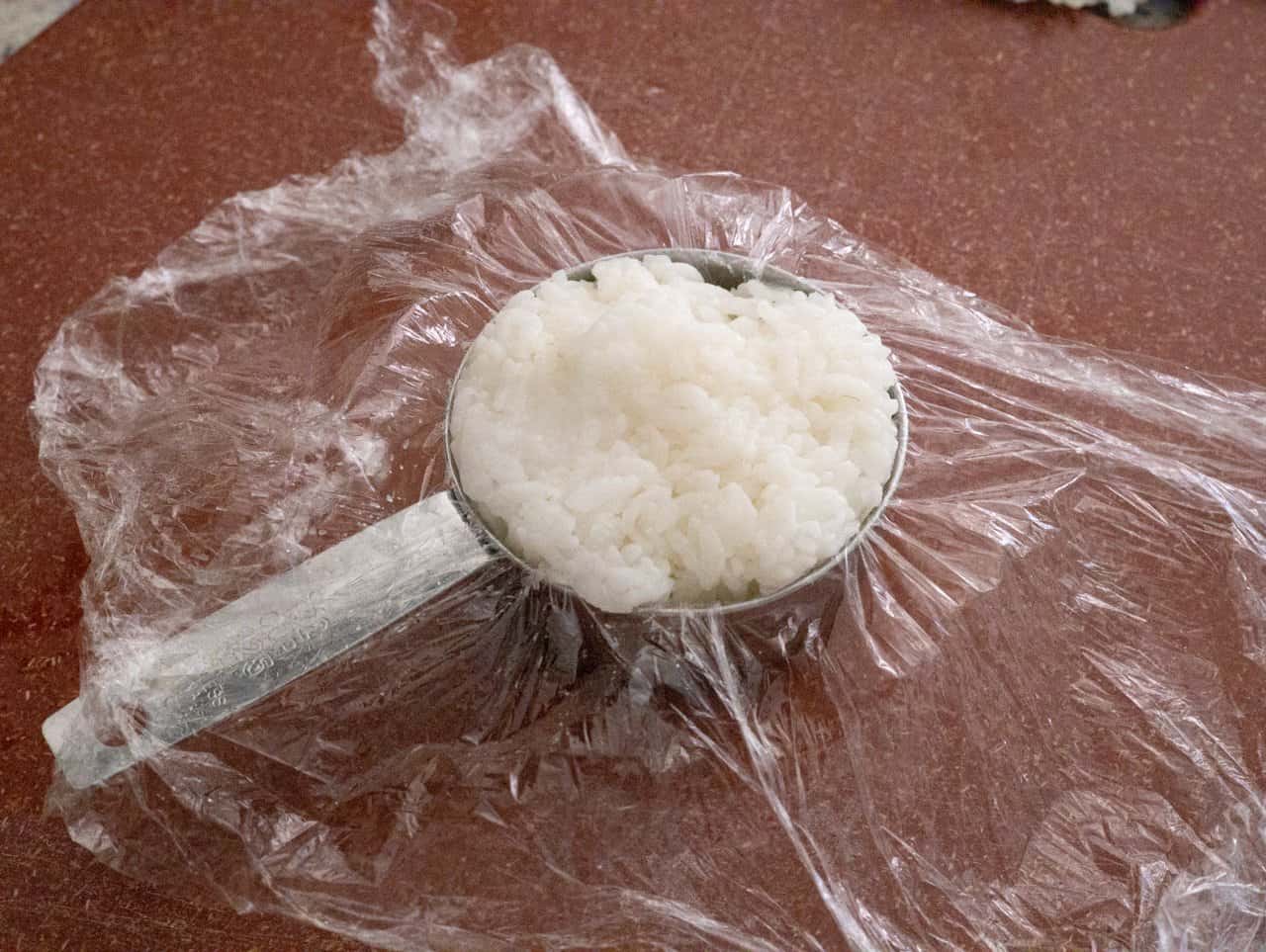 Fill measuring cup with rice