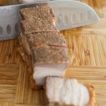 Turn the pork belly skin side down on a cutting board. With a sharp knife, slice into the meaty side in a sawing motion. Then when you reach the skin, slice down with one swift chop.  In a small bowl, combine hoisin and rice vinegar. Serve with pork belly slices. 