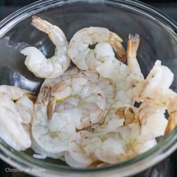 If needed, peel and devein the shrimp either removing the tails or leaving them on.  Rinse peeled shrimp with running cold water to remove any dirt or tiny shells. Strain and shake out any excess water. 