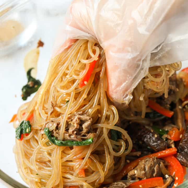 Japchae noodles tossed with beef, vegetables, and sesame soy sauce.