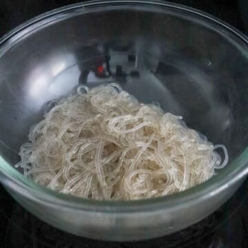 Cooked Korean sweet potato glass noodles in a large mixing bowl.