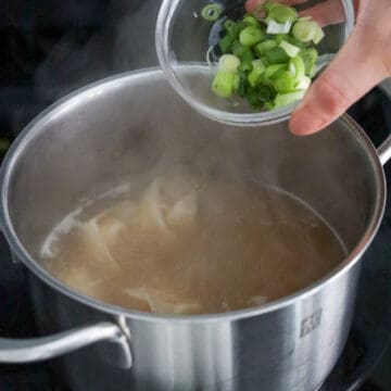 Season broth with white pepper to taste and add green onions. Remove off heat and keep warm.