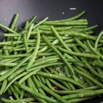 Toss in green beans. Once tossed, add water to help cook them faster. 