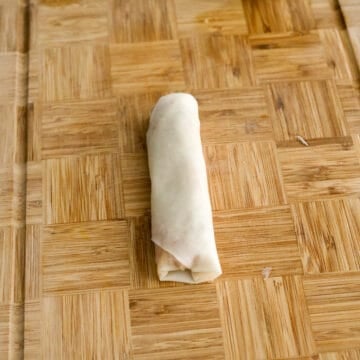 Tightly roll the egg roll upwards. Repeat this process for remaining filling. Place egg rolls on parchment paper.