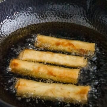 In a heavy bottomed pan on medium heat, add 2-3 cups of oil. Once oil is hot or at 350 F degrees, gently lower 3-4 egg rolls away from you. Fry in small batches for 3 minutes turning over half way. Do not overcrowd the pan.
