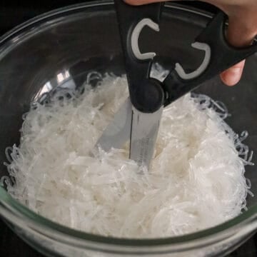 Transfer noodles to a large bowl and cut them with clean kitchen scissors.