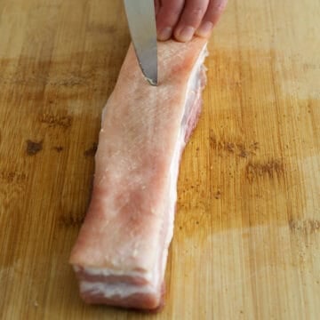 With the pointy tip of a sharp paring knife or a clean scoring blade, carefully and lightly score as many tiny cross hatches into the thick skin. Do not pierce the skin. 