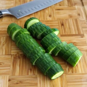 Trim the ends off the cucumbers and slice the cucumber into 1-cm thick rounds. Transfer to a large bowl.