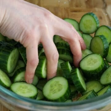 Sprinkle salt on top of cucumber slices. Massage salt into cucumbers.