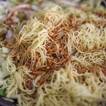 Push the veggies to the side of the pan. Add remaining oil into empty space and add noodles and sauce. 