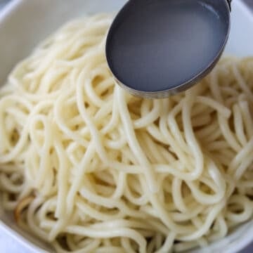 Place hot noodles on top of the Noodle sauce followed by noodle water