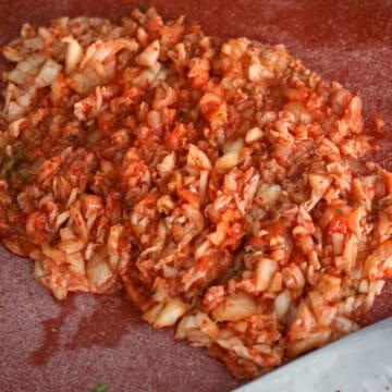 ​On a cutting board, finely chop kimchi. Transfer to a large mixing bowl. 