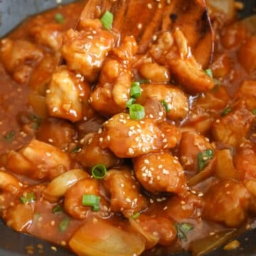 Reduce to medium heat. Add the fried chicken and toss to coat evenly. Garnish with green onions and sesame seeds. Enjoy!