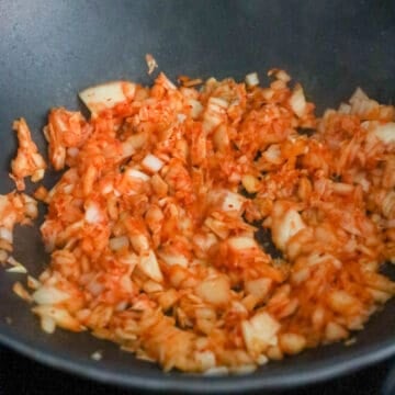 Fry in garlic, onion and chopped kimchi. Stir fry until onions are translucent and kimchi has released some of its juices, about 45-60 seconds. 