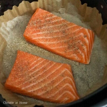 To air fry: Line the air fryer basket with air fryer parchment paper or aluminum foil. Place the salmon filets skin side down in a single layer without overlap. Evenly season the salmon with salt, black pepper and garlic powder. 