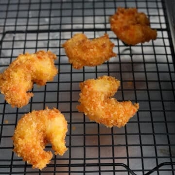 Remove and transfer fried shrimp to a wire rack to remove excess oil. 