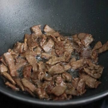 Heat vegetable oil in a large pan on medium-high heat. Fry marinated beef in a single layer until cooked and slightly browned on edges. Remove and set aside. 