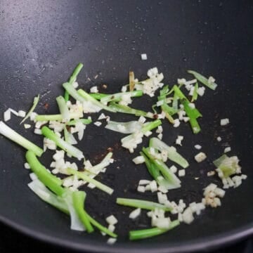 With the residual oil in the pan, fry scallion whites only and garlic for 10 seconds. 