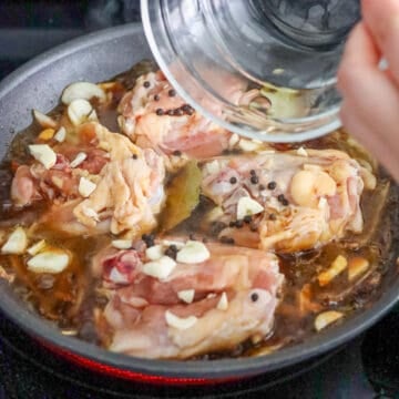 Add soy sauce, sliced garlic, whole black peppercorns, bay leaves and lastly, the vinegar. Do not stir the sauce or it will end up tasting too acidic because the vinegar didn't have a chance to fully evaporate. The simmering process will create a balanced tasting sauce so don't panic if it tastes very tangy at this point. 