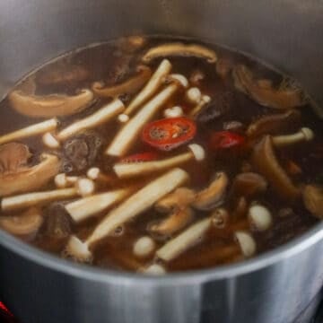 reduce to low-medium heat. Add in shiitake mushrooms, carrots, seafood mushrooms, red chili and boil uncovered for 2 minutes