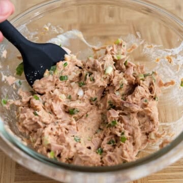 Strain the canned tuna with a fine sieve and a fork to force the liquids out. Discard the liquids. Then in a medium bowl, combine strained tuna, green onions, Japanese mayo and sriracha sauce with a fork to make your spicy tuna filling. Set aside.