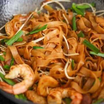 Toss in cooked shrimp and sausage and mix with noodles. Then finally toss in the bean sprouts and garlic chives and stir fry for another 20 seconds. Remove off heat to serve. 