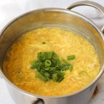 Pour eggs in a thin stream while stirring the soup and garnish with green onions.