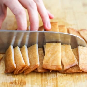 First slice fish cake sheets horizontally into ¾-inch stripes. Then slice the stripes into half. 