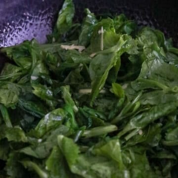 Next toss in snow pea leaves and mix with garlic and ginger. Cook until snow pea leaves have softened, about 1-2 minutes.