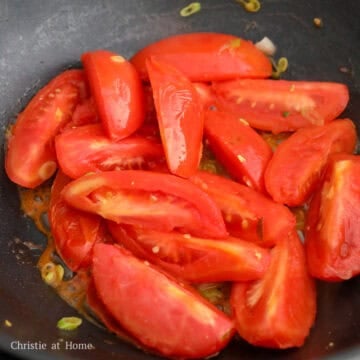 Add the remaining oil into the pan. Sauté the white part of the green onions for 5 seconds.  Add the chopped tomatoes and water. Cook tomatoes for 2-3 minutes or until softened and the skin begins to peel away.