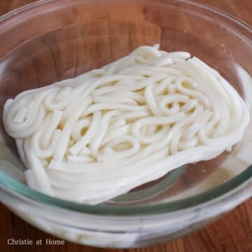 In a large bowl, soak udon noodles in boiling water for about 30 seconds, just until loosened. Strain and set aside.
