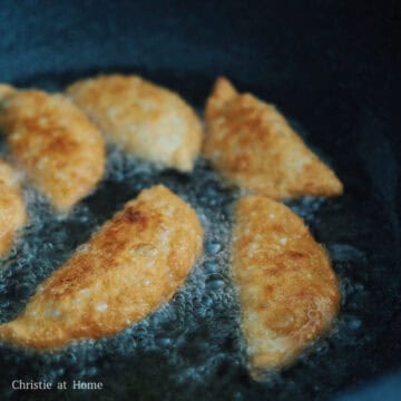 Heat 2-inches of vegetable oil in large heavy-bottomed pan on medium heat, around 350 F or insert a wooden utensil into the oil and look for bubbles. Lower 6 curry puffs into the hot oil with a slotted spoon. Fry for 3-4 minutes in total until golden brown, flipping half way. Remove and transfer to a wire rack or paper-towel lined baking sheet to drain off oil. Let them cool down a bit before enjoying!