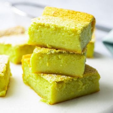 Baked pandan custard cake with a lightly browned top cooling before slicing.