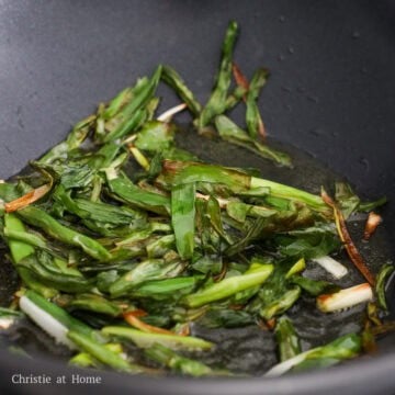 Fry the scallions in oil until golden and slightly browned.
