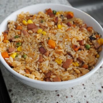 Divide fried rice into two serving bowls and firmly pack it into the bowls.
