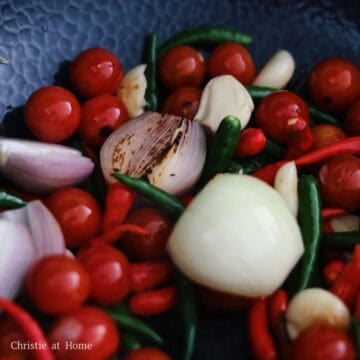 Heat 2 tablespoon or 30 ml vegetable oil in a large pan or wok on high heat. Add red and green chili peppers, onion, shallots, tomatoes and garlic cloves. Char them until the edges are browned.