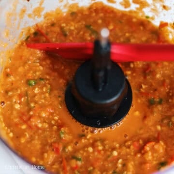 Next transfer the charred ingredients in the pan to a blender, food processor or stone mortar and pestle. Then blend on high or pound the ingredients into a chunky paste. 