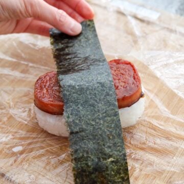 Finished Spam musubi assembled with glazed Spam, rice, and nori wrap.