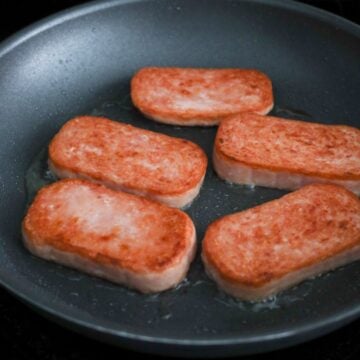 Heat vegetable oil in a large skillet on medium heat. Fry slices of spam in a single layer for 1 ½ to 2 minutes per side, until pinkish golden brown. Do not go above medium-high heat.
