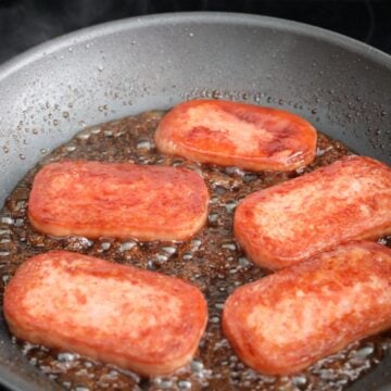 Pour teriyaki sauce over cooked spam slices and let it fry in sauce for 1 minute on each side until it becomes a thick glaze. Remove spam from hot pan and transfer to an oiled plate to prevent the spam from sticking to plate. Note: Do not leave spam in pan as the teriyaki glaze will start to burn it with the residual heat.