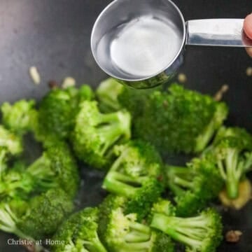 Add ginger, garlic, broccoli, and water into the pan and stir fry for 1 minute.