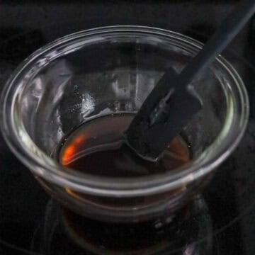 Whisk blending dark savory sauces and sesame oil together.