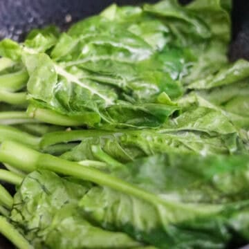 Vibrant green Chinese broccoli tossing with minced garlic.