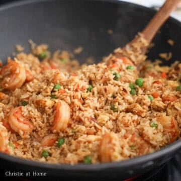 Mix in the shrimp. Add rice and pour the sauce around the rice along the edges of the pan. Toss everything together until all rice grains are colored brown. Remove off heat and garnish with green onions.