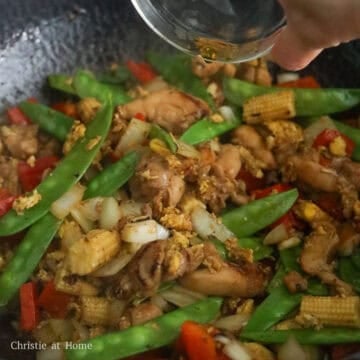 Add onions, garlic, red bell peppers, snap peas and baby corn and stir fry until softened. Pour in Shaoxing wine and allow the alcohol to evaporate.