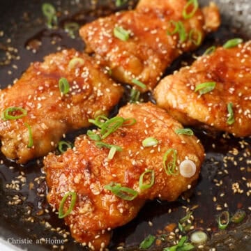 Add the chicken skin-side down into the sauce. Then quickly flip it over to coat the other side. Remove off heat. Garnish with sesame seeds and green onions. Serve as whole pieces or let it rest for 5 minutes and slice thighs into strips. Enjoy!