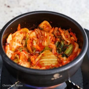 Heat vegetable oil in a small pot on medium heat. Sauté sliced onions and minced garlic until softened. Then sauté the chopped kimchi for 2 minutes. 