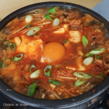 Crack a raw egg into the centre of the stew on top of the tofu and let the egg cook until your desired preference. Remove off heat. Use oven mitts if you're using a earthenware pot. Garnish with green onions and enjoy with a side of rice!
