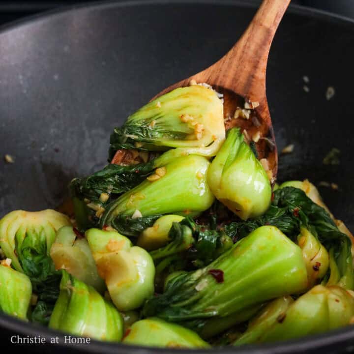 Tender baby bok choy coated in glossy red spicy garlic sauce.